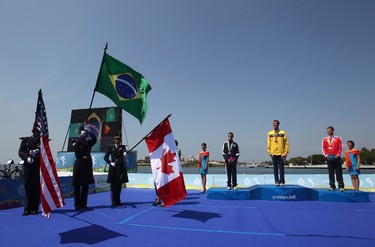 Gold medalist Reinaldo Colucci (C), of Brazil, silver medalist Manuel Huerta (L), of the U.S., and bronze medalist Brent McMahon, of Canada, listen to the Brazilian anthem after the men's triathlon competition at the Pan American Games in Mexico on Oct. 23, 2011. (REUTERS)