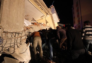 Rescue workers try to save people trapped under debris after an earthquake in Ercis, near the eastern Turkish city of Van, October 23, 2011. As many as 1,000 people were feared killed on Sunday when a powerful earthquake struck Turkey, collapsing dozens of buildings and pulling down phone and power lines in the southeast of the country, officials and witnesses said. REUTERS/Osman Orsal