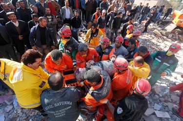 Emergency service workers carry a victim of the earthquake during the rescue operations in Ercis, near the eastern Turkish city of Van, October 24, 2011. (REUTERS/Osman Orsal)