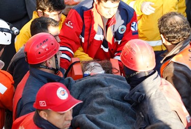 Tugba Ozbek, a 24-year-old high school teacher and earthquake survivor, is carried out on a stretcher by rescue workers, from a collapsed building after an earthquake in Ercis, near the eastern Turkish city of Van, October 24, 2011. (REUTERS/Umit Bektas)