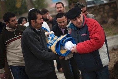 Turkish men carry the body of their relative that was killed during an earthquake, at a cemetery in Ercis, Turkey October 25, 2011. (REUTERS/Morteza Nikoubazl)