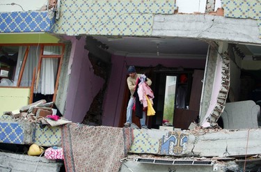 An earthquake survivor collects his belongings in a collapsed building in Ercis, near the eastern Turkish city of Van, October 25, 2011. (REUTERS/Osman Orsal)