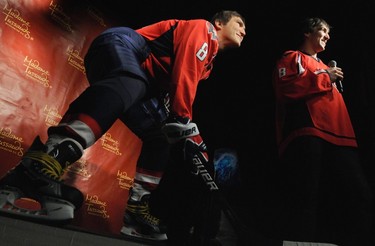 Russia's Alex Ovechkin (R), star forward for the Washington Capitals of the NHL, talks with reporters at the unveiling of his wax likeness in hockey gear at Madame Tussauds wax museum in Washington on Oct. 24, 2011. (REUTERS)