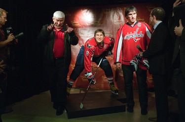 Mikhail Ovechkin (L) signals that he'd like a copy of a photo with his son Alex Ovechkin (R), star forward for the Washington Capitals of the NHL, and his wax likeness in hockey gear during an unveiling at Madame Tussauds wax museum in Washington on Oct. 24, 2011. (REUTERS)