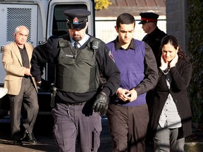 Hamed Shafia (centre) enters Frontenac County Court in Kingston, Ont. on Oct. 25,  with his mother Tooba Mohammad Yahya and father Mohammad Shafia.  (IAN MACALPINE/QMI AGENCY)