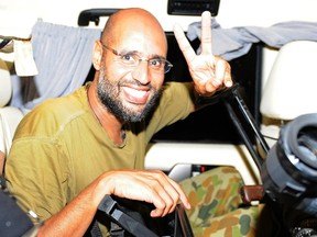 Saif al-Islam, the son of Libyan leader Muammar Gadhafi, gestures as he talks to reporters in Tripoli in this August 23, 2011 file photo. The International Criminal Court's prosecutor Luis Moreno-Ocampo said on October 28, 2011, that his office was in "informal contact" with al-Islam, through intermediaries regarding his surrender to the war crimes court.  REUTERS/Paul Hackett/Files