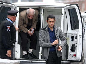 Hamed Shafia (foreground) and his father Mohammad enter court in Kingston, Ont. on November 1, 2011 to start the third week of their first degree murder trial. (IAN MACALPINE/QMI Agency)