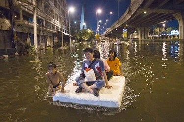 A boy and girl give rides for a fee to flooded residents in Bangkok November 2, 2011. The floods began in July and have devastated large parts of the central Chao Phraya river basin, killed nearly 400 people and disrupted the lives of more than two million. (REUTERS/Adrees Latif)