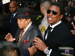 Michael Jackson's father Joe (L) and brother Jermaine Jackson leave the courthouse after the reading of the guilty verdict in Dr. Conrad Murray's trial in Los Angeles, November 7, 2011.(FILE)