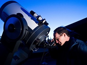 Public programs director Frank Florian looks through a telescope at the Telus World of Science observatory on Tuesday. (CODIE MCLACHLAN/EDMONTON SUN)