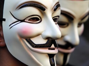 Demonstrators wearing Anonymous masks participate in a sit-in protest near the Bank of Italy's headquarters in Rome October 12, 2011. Anonymous is threatening to launch a cyber attack on the city should civic authorities move to dismantle Occupy Toronto's encampment in a downtown park. REUTERS/Stefano Rellandini