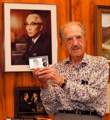 Albert Cohen, chairman of Sony, holds up one of the first transistor radios ever in Canada. In background photo is Akio Morita, the founder of Sony.