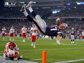 New England Patriots tight end Rob Gronkowski (top) scores a touchdown over Kansas City Chiefs linebacker Derrick Johnson in the second half of their NFL football game in Foxborough, Massachusetts November 21, 2011.  (REUTERS/Brian Snyder)