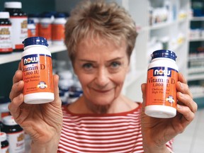Gail Hersee of Strickly Supplements holds a pair of bottles of vitamin D tablets. (QMI Agency file)