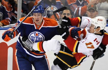 Calgary Flames' Rene Bourque (R) is hit by Edmonton Oilers' Ladislav Smid during the third period of their NHL hockey game in Edmonton December 3, 2011. (REUTERS/Dan Riedlhuber)
