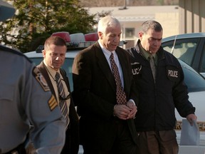 Former Penn State University assistant football coach Jerry Sandusky (C) is led away by police after being arrested in a sex crimes investigation, in Harrisburg, Pennsylvania. (REUTERS/HO)