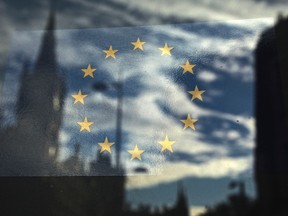 The European Union flag is pictured in a window reflecting a street in London, October 26, 2011. (REUTERS/Luke MacGregor)