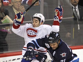 Montreal Canadiens left winger Max Pacioretty (left) is checked by Winnipeg Jets defenceman Dustin Byfuglien during NHL hockey in Winnipeg Thursday, December 22, 2011. (BRIAN DONOGH/Winnipeg Sun)