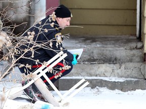 A Winnipeg Police forensics officer investigates behind a house at 691 Selkirk Ave. on Dec. 31, 2011 following a murder at the home. Police announced an arrest in the case on Tuesday. (BRIAN DONOGH/WINNIPEG SUN FILE PHOTO)