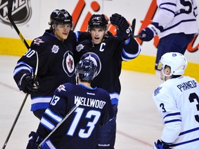 Winnipeg Jets' Andrew Ladd (3rd L) celebrates his second period goal against the Toronto Maple Leafs with teammates Nik Antropov (L) and Kyle Wellwood (13) during their NHL hockey game in Winnipeg December 31, 2011. (REUTERS/Fred Greenslade)