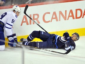 Winnipeg Jets' Evander Kane (R) is run into the boards by Toronto Maple Leafs' Keith Aulie during the first period of their NHL hockey game in Winnipeg December 31, 2011. (REUTERS/Fred Greenslade)