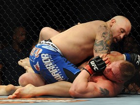 (L-R) Shane Carwin holds down Brock Lesnar in the first round during the UFC Heavyweight Championship Unification bout at the MGM Grand Garden Arena on July 3, 2010 in Las Vegas, Nevada. (Getty Images)