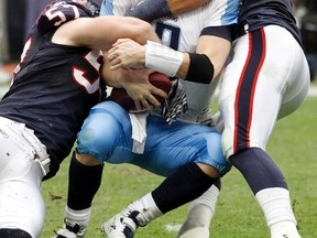 Titans quarterback Matt Hasselbeck is sacked by Texans linebackers Jesse Nading (left) and Bryan Braman in Houston, Tex., Jan. 1, 2012. (RICHARD CARSON/Reuters)