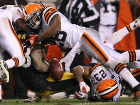 Steelers running back Isaac Redman fumbles the ball while being tackled by Browns defenders (left to right) Mike Adams, Usama Young and Joe Hayden in Cleveland, Ohio, Jan. 1, 2012. (AARON JOSEFCZYK/Reuters)