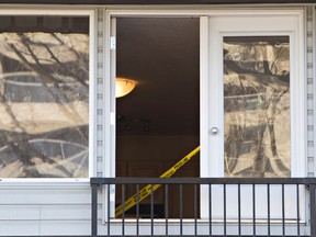 Caution tape can be seen in the open patio door of a second-floor suite after an Edmonton landlord made a grisly discovery on January 1, 2012. (AMBER BRACKEN/QMI Agency)