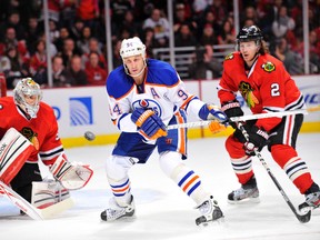 Ryan Smyth takes a whack at an airborne puck in front of Hawks goaltender Corey Crawford Monday in Chicago. (Rob Grabowski, U.S. Presswire)