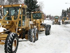 Edmonton snow removal crews using graders and a giant snow blower work on 92 Ave., just west of 50 St., in Edmonton Jan. 21, 2011. TOM BRAID/EDMONTON SUN