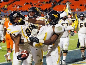West Virginia Mountaineers wide receiver Willie Milhouse is picked up by teammates after scoring a touchdown against the Clemson Tigers during the Orange Bowl in Miami, Fla., Jan. 4, 2012. (JOE SKIPPER/Reuters)
