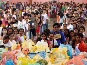 Evacuees queue for relief goods at an evacuation centre for tropical storm Washi survivors in the southern Philippines city of Cagayan de Oro in Mindanao January 4, 2012.  A landslide hit the Philippines early Thursday, killing 25 people. (REUTERS/Erik De Castro)