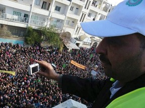 An Arab League observer takes photos for anti-government protesters on the streets in Adlb December 30, 2011. (REUTERS/Handout)