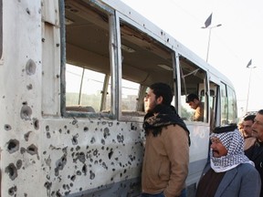 People inspect a damaged bus after a bomb attack in Sadr city in eastern Baghdad January 5, 2012. (REUTERS/Kareem Raheem)