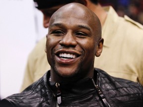 U.S. boxer Floyd Mayweather Jr. smiles after sitting courtside at the NBA basketball game between the Chicago Bulls and Los Angeles Clippers in Los Angeles Dec., 30, 2011. (REUTERS/Danny Moloshok)