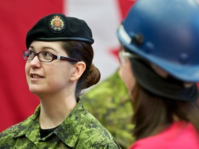 Leading Seaman Connie Wolff speaks with Alex Cullen — a Boilermakers member and a tig welder — after Prime Minister Stephen Harper announced $150,000 in funding for the Helmets to Hardhats program at the Boilermakers Training Centre Jan. 6. IAN KUCERAK/EDMONTON SUN