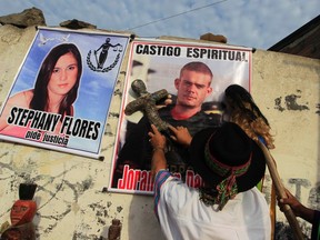 A shaman performs a ritual in front of pictures of Dutch citizen Joran Van der Sloot (R) and Peruvian Stephany Flores to ask for spiritual punishment for Van der Sloot, outside the Lurigancho prison in Lima January 6, 2012.  REUTERS/Pilar Olivares