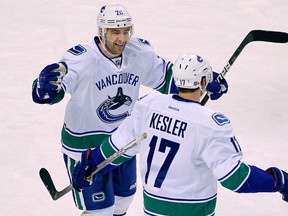 Vancouver Canucks center Ryan Kesler is congratulated by teammate Christopher Higgins after scoring a goal against the Boston Bruins in the first period action during their NHL hockey game in Boston, Massachusetts January 7, 2012.  (REUTERS/Adam Hunger)