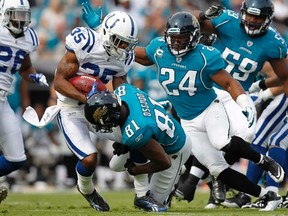 Jaguars' Montell Owens (24) and Kassim Osgood (81) tackle Joe Lefeged (35) of the Colts during first half action in Jacksonville, Fla., on Jan. 1, 2012. (Joe Robbins/Getty Images/AFP)