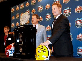 Coaches Nick Saban of Alabama (left) and Les Miles of LSU pose with the BCS trophy at a news conference on Sunday in New Orleans. The two teams square off for the title on Monday night. (Getty Images)