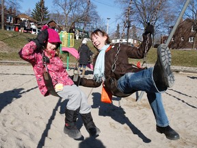 City Councillor Mary-Margaret McMahon plays on a swing with Amelia Doty at Bowmore School. Concerned residents and the  councillor voiced concern about proposed budget cuts. (CRAIG ROBERTSON, Toronto Sun)