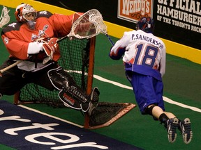 Calgary Roughnecks goalie Mike Poulin snares the ball in his stick as the Rock’s Phil Sanderson  leaps to try to score in the fourth period of their NLL encounter at the Air Canada Centre on Sunday night.  (Jack Boland, Toronto Sun)