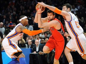 Raptors' Andrea Bargnani drives to the basket between Knicks' Carmelo Anthony (L) and Josh Harrellson (R) during the first quarter in New York last night. (REUTERS/Bill Kostroun)