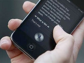 Luke Peters demonstrates Siri, an application which uses voice recognition and detection on the iPhone 4S, outside the Apple store in Covent Garden, London Oct. 14, 2011. (REUTERS/Suzanne Plunkett)