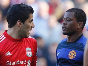 Liverpool's Luis Suarez  and Manchester United's Patrice Evra look at each other during their English Premier League soccer match at Anfield in Liverpool, northern England Oct., 15, 2011. (REUTERS/Phil Nobl)