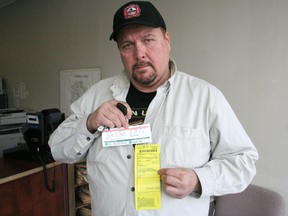 Kirk Lewis holds up his $450 parking ticket. (DAVE FLAHERTY/QMI Agency)