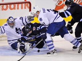 Winnipeg Jets' Kyle Wellwood collides with Toronto Maple Leafs goaltender James Reimer as he is checked by Dion Phaneuf during the third period of their NHL hockey game in Winnipeg Dec. 31, 2011. (REUTERS/Fred Greenslade)