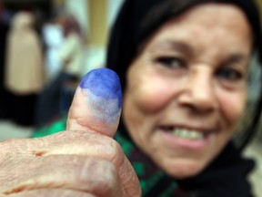 A woman shows her ink-stained finger after casting her vote in Toukh, El-Kalubia governorate, about 25 km (16 miles) northeast of Cairo January 3, 2012. (REUTERS/Amr Abdallah Dalsh)