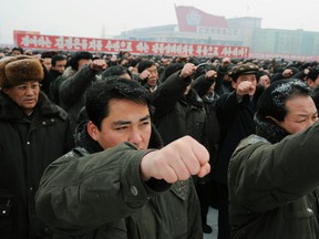 North Koreans raise their fists as they attend a mass rally at Kim Il-Sung square in Pyongyang, in this photo taken by Kyodo January 3, 2012. (REUTERS/Kyodo)